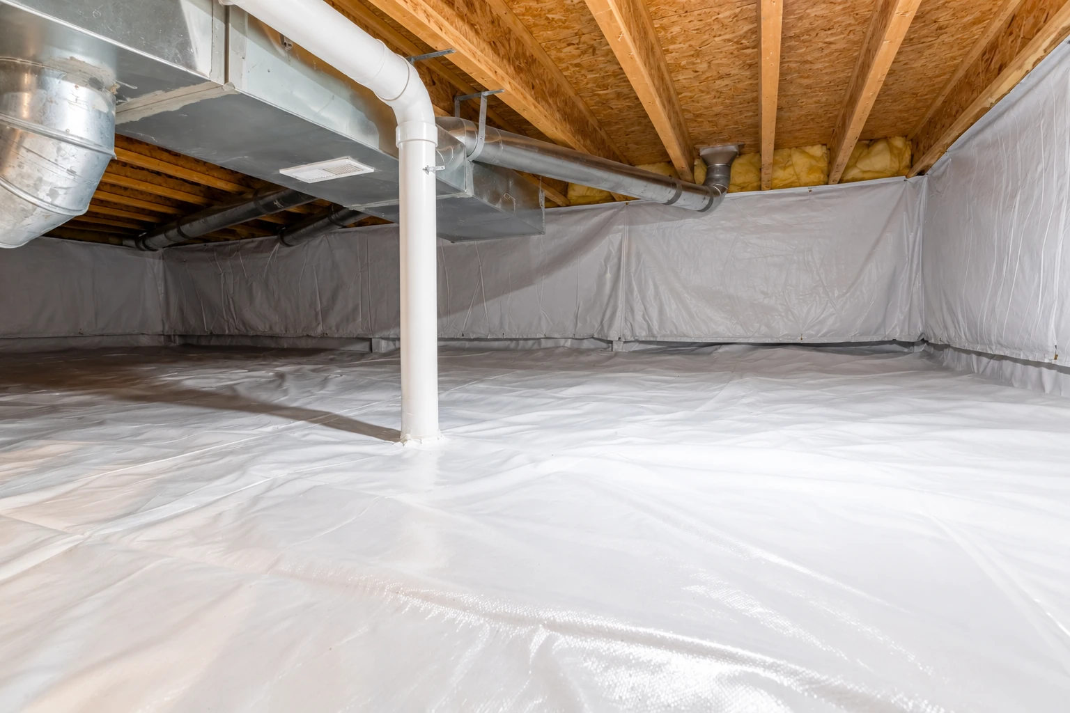 Crawl space with a white vapor barrier covering the floor and walls beneath exposed wooden joists and metal ductwork.
